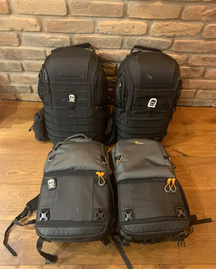 4 bags. The top two are identical black tactical style backpacks. The bottom 2 are identical hiking style backpacks.