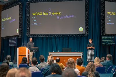 Craig on the stage at accessibility scotland in front of a slide which reads "WCAG has 2 levels, if we're honest".
