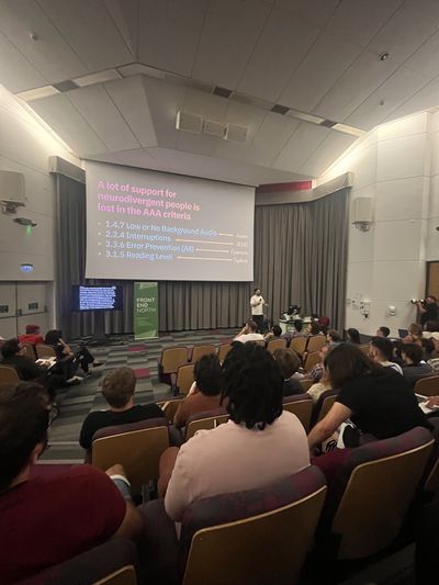 Craig presents to a full Front End North auditorium in Sheffield, beneath a slide titled "A lot of support for neurodivergent people is lost in the AAA criteria", mapping WCAG criteria to autism, ADHD, dyspraxia and dyslexia.